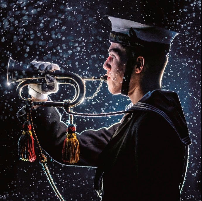 Christmas card showing a cadet playing a bugle in the snow