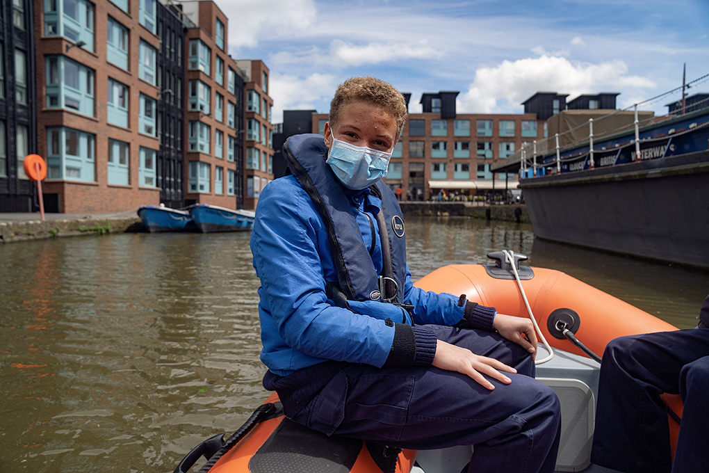 Photo of a cadet wearing a face mask on a boat