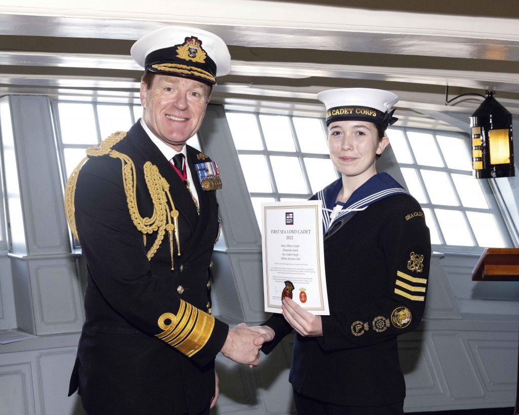 Alexandra shakes hands with the First Sea Lord as she accepts her certificate