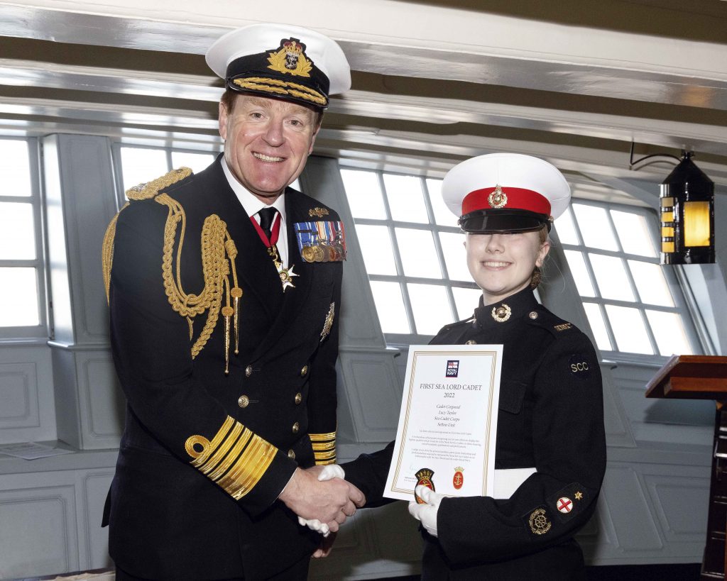 Lusy shakes hands with the First Sea Lord as she receives her certificate
