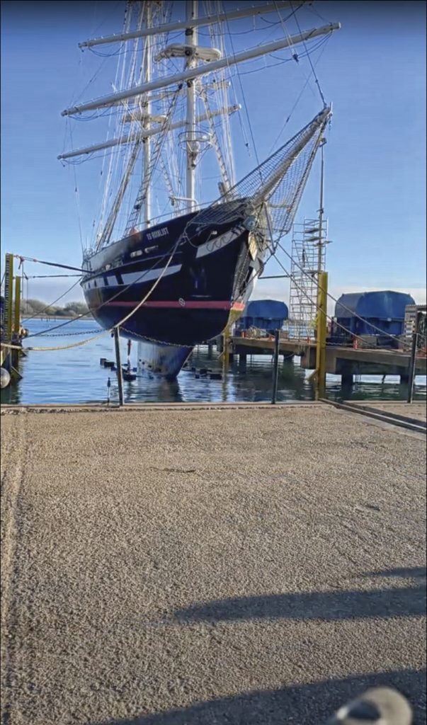 TS Royalist hovers over the water as it is lifted out to be cleaned