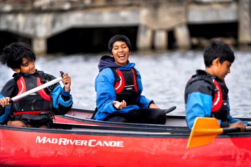 Young people smile and laugh as they take part in On The Water