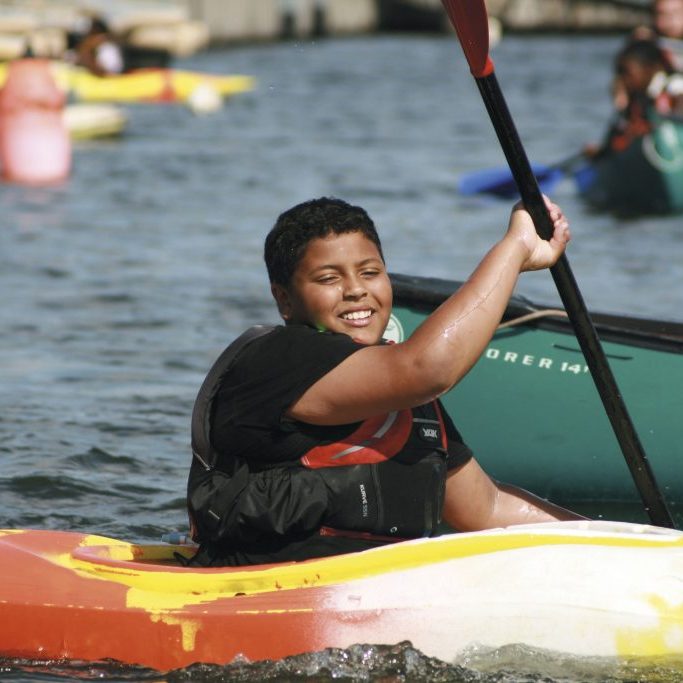 Smiling cadet paddling a kayak