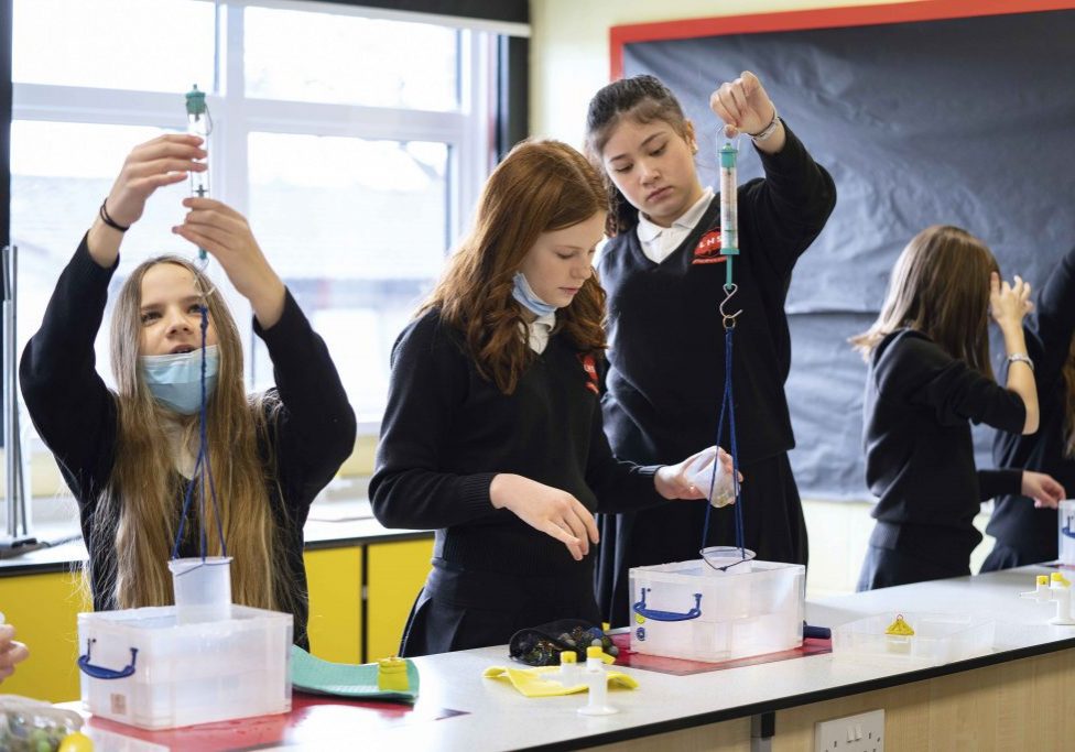 School pupils carry out engineering experiments in a classroom