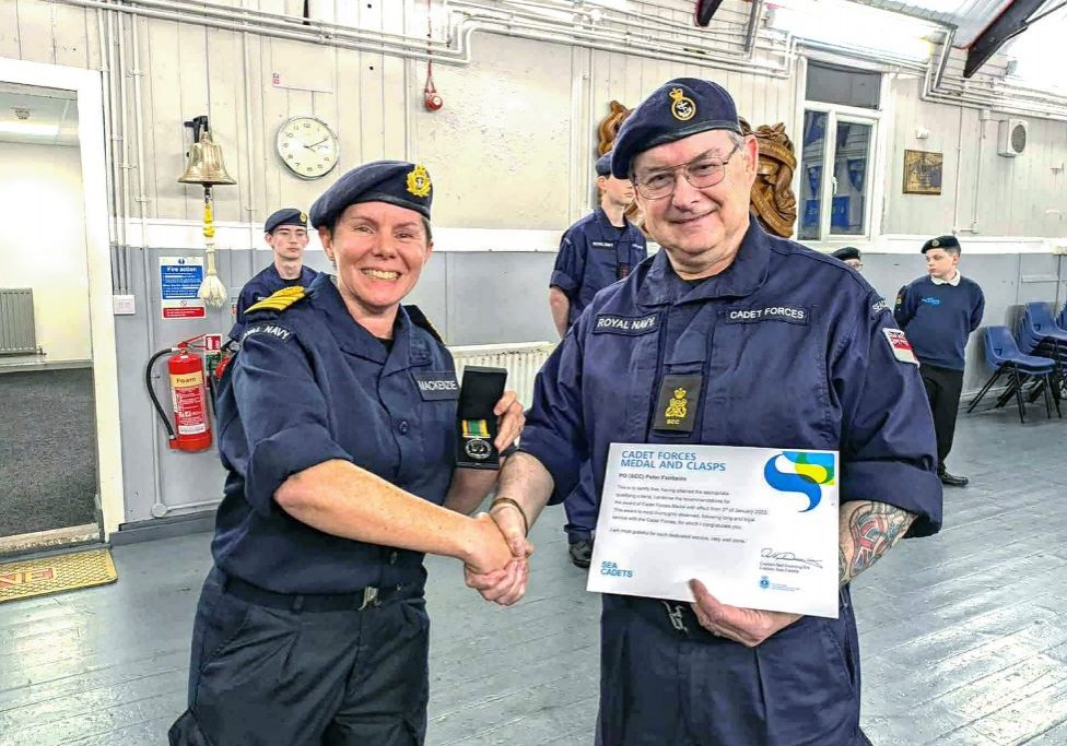 Captain Hannah presenting PO Fairbairn with a Cadet Forces Medal