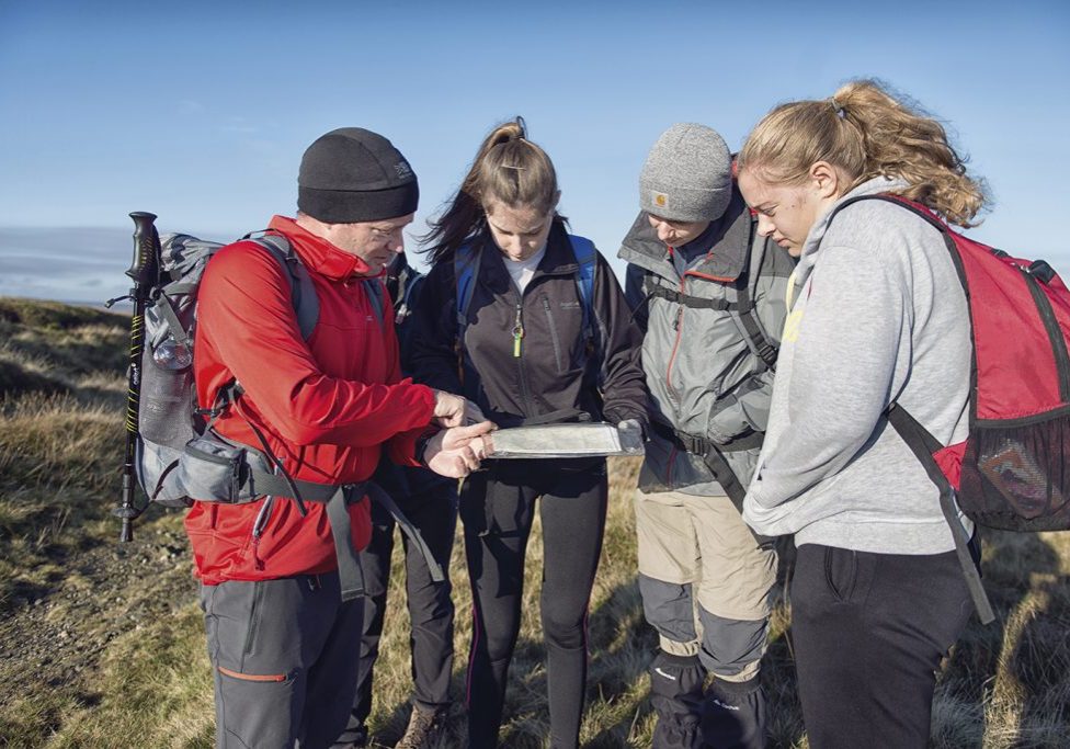 Young people looking at a map in an outdoor setting