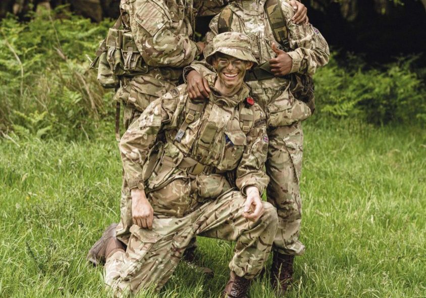 Three smiling royal marines cadets pose together